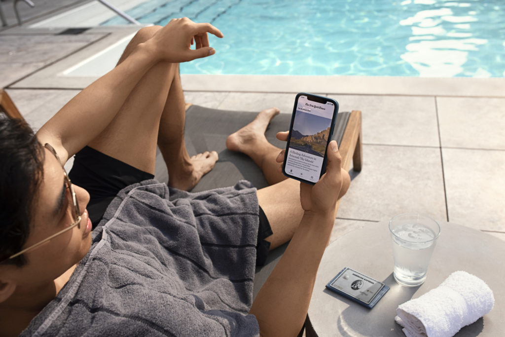 man sitting by a pool with a cell phone